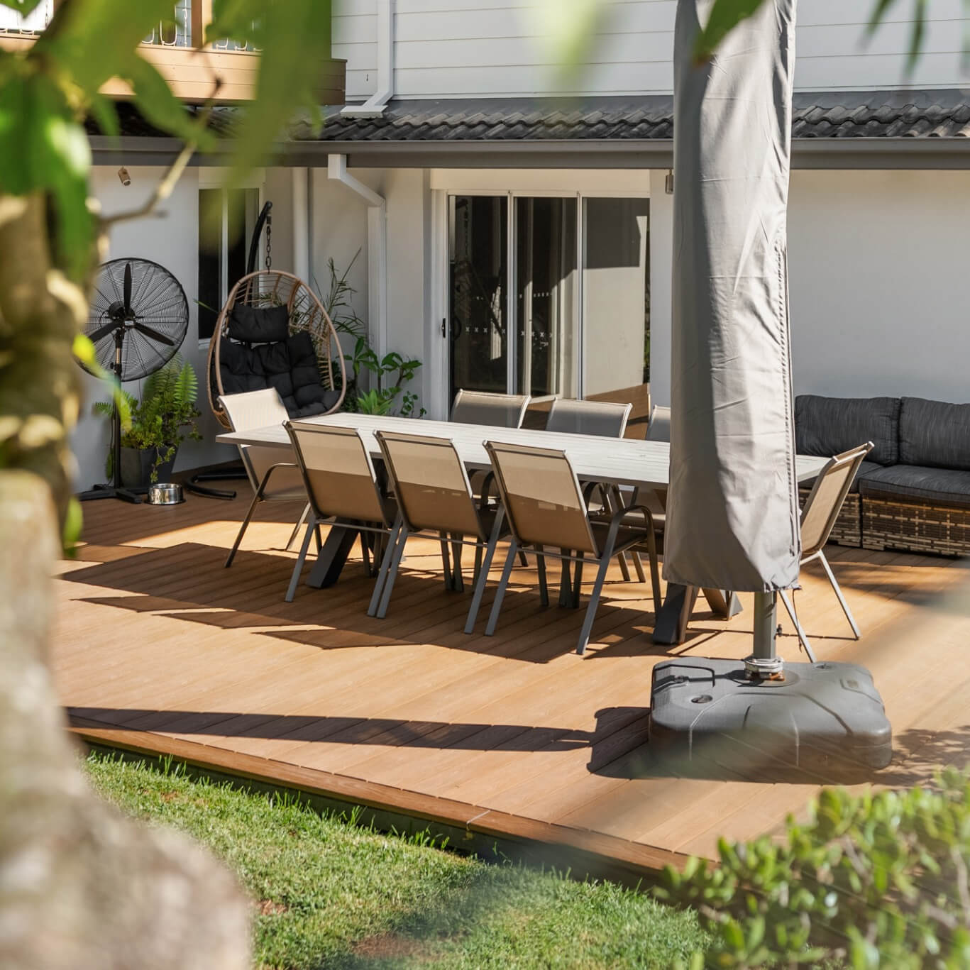 WoodEvo Advanced composite deck in Oak off the back of the house, with frameless glass pool fencing alongside, Mona Vale